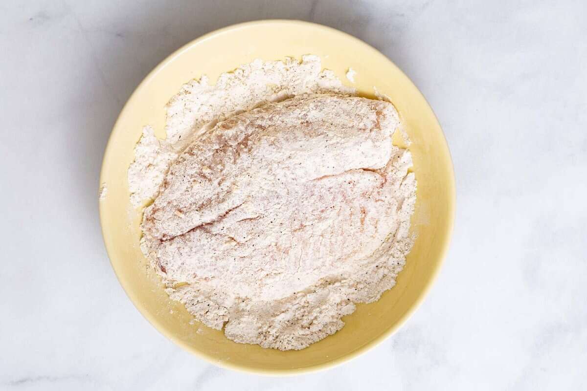 Tilapia in bowl of flour.