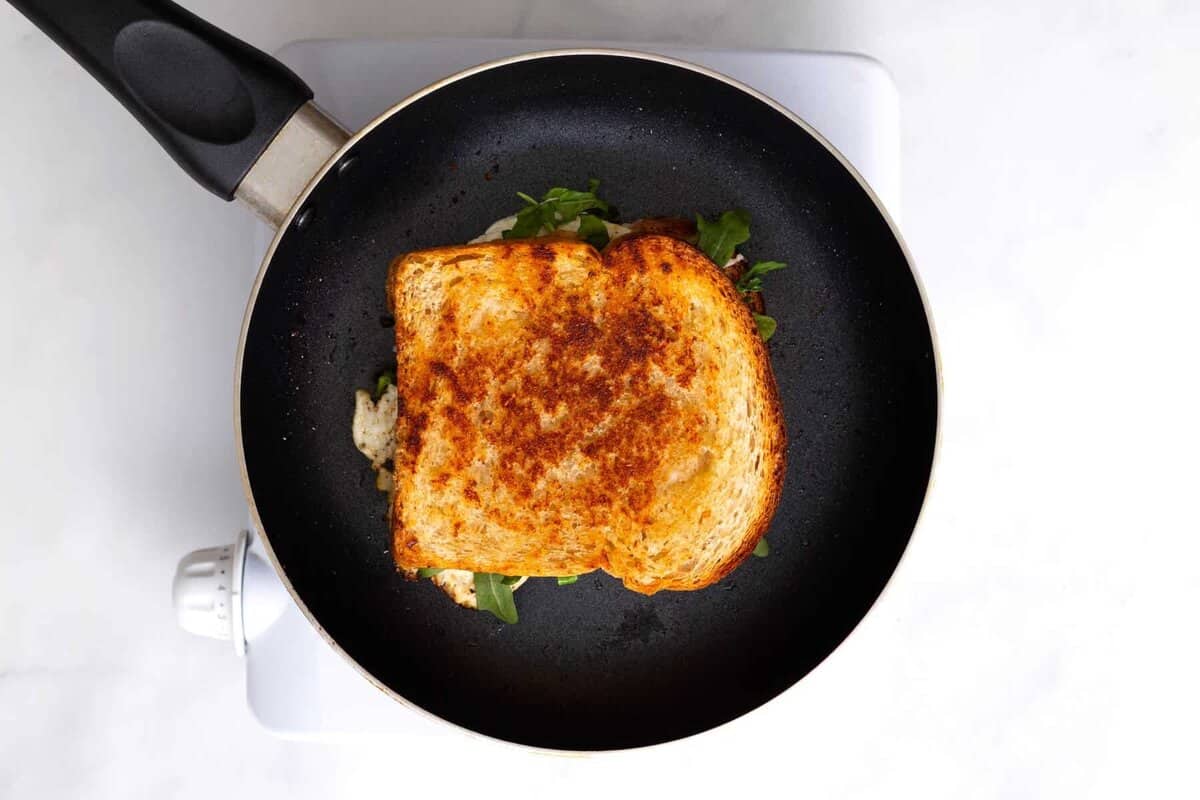 Egg and cheese sandwich in skillet.