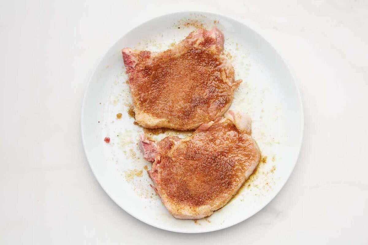 Bone-in pork chops rubbed with seasonings.