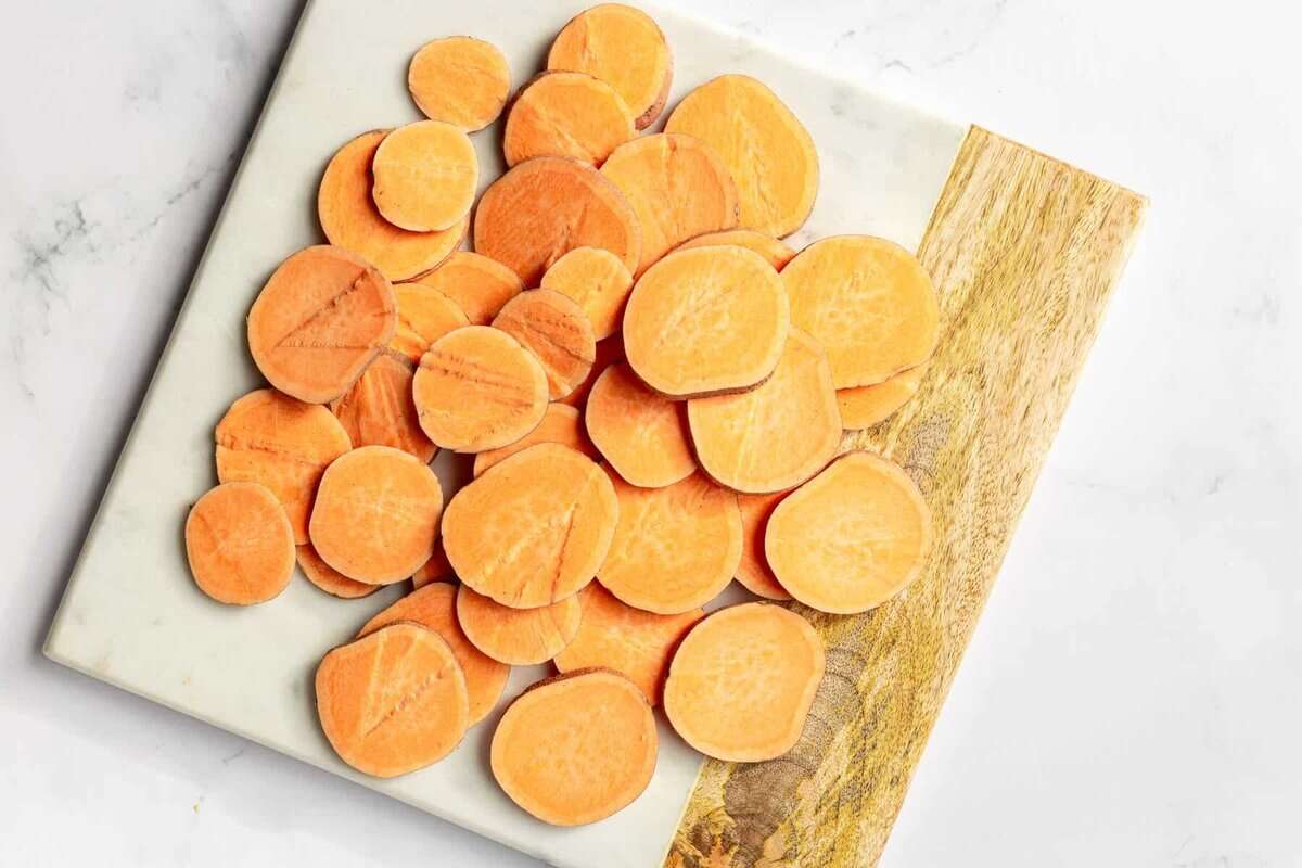 Sliced sweet potatoes on cutting board.