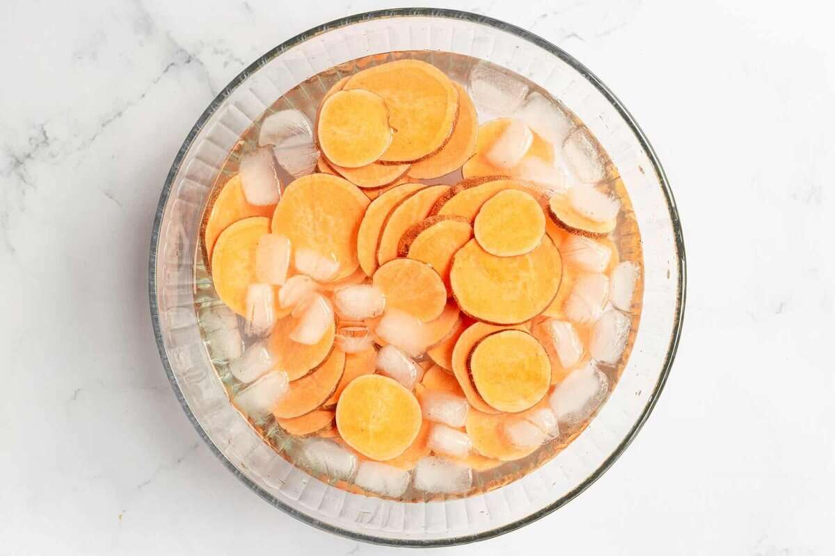 Sweet potato slices soaking in ice water.
