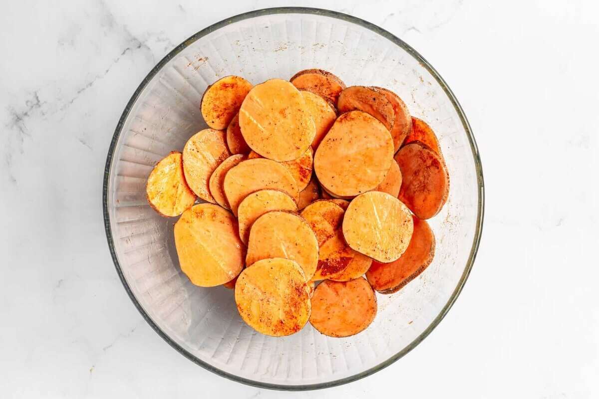 Sweet potato chips in bowl with seasonings.