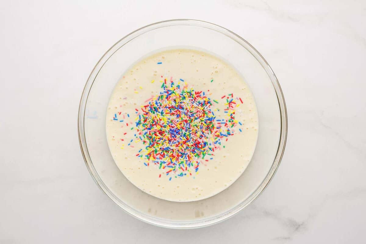 Cake mix with rainbow jimmies added to bowl.