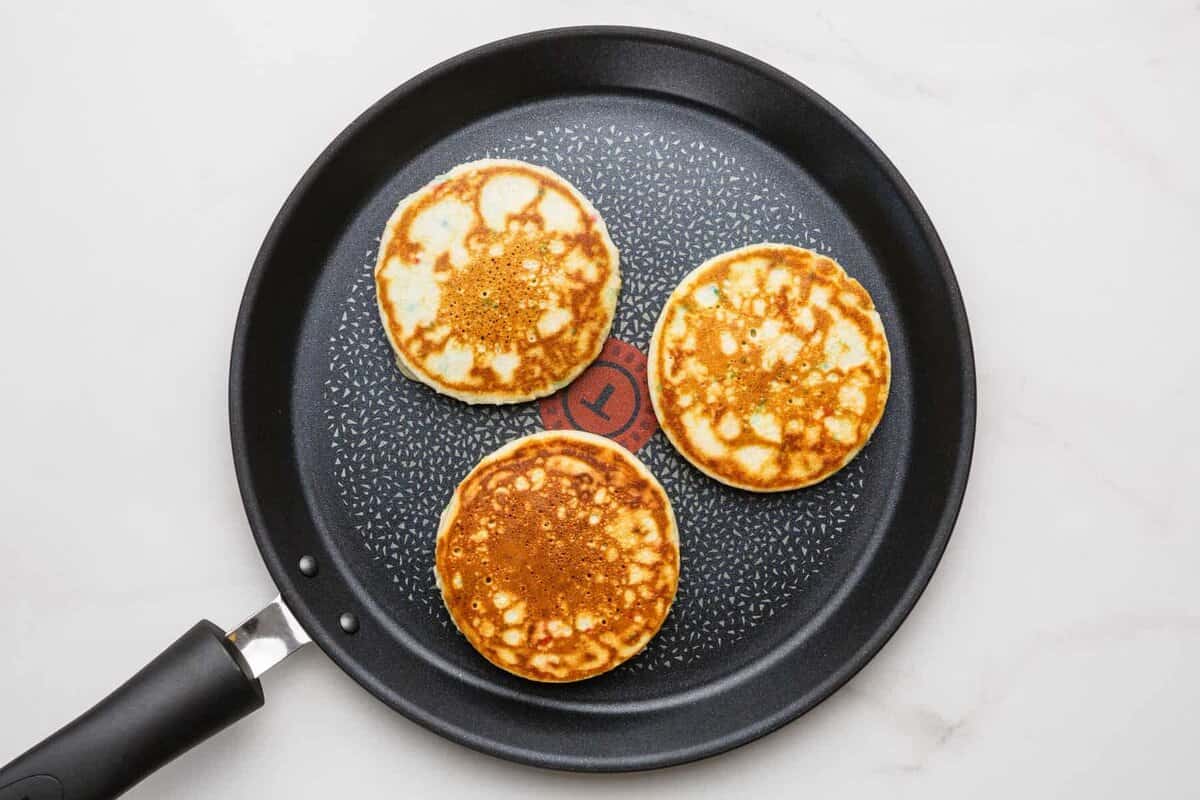 Birthday cake pancakes in skillet.