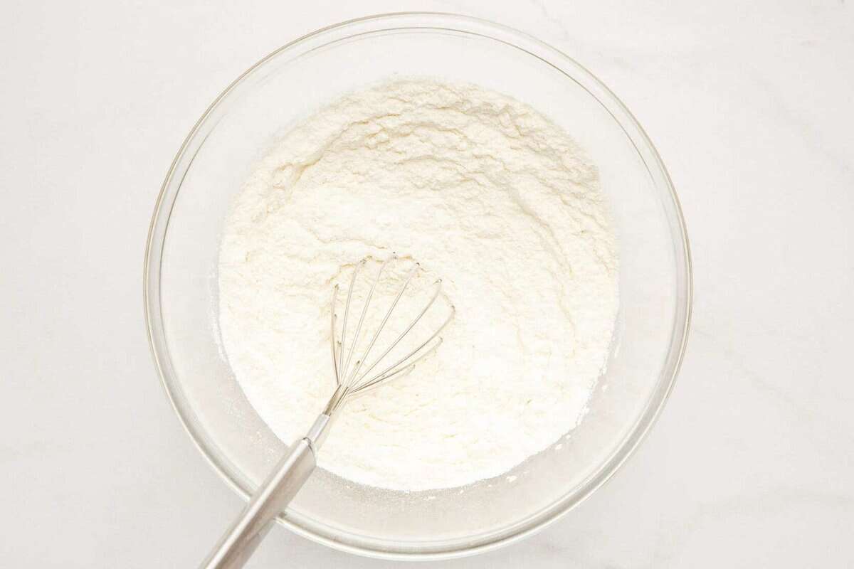 Whisk in bowl with dry waffle ingredients.
