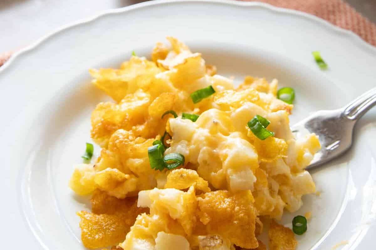 Serving of cheesy potatoes on plate with fork
