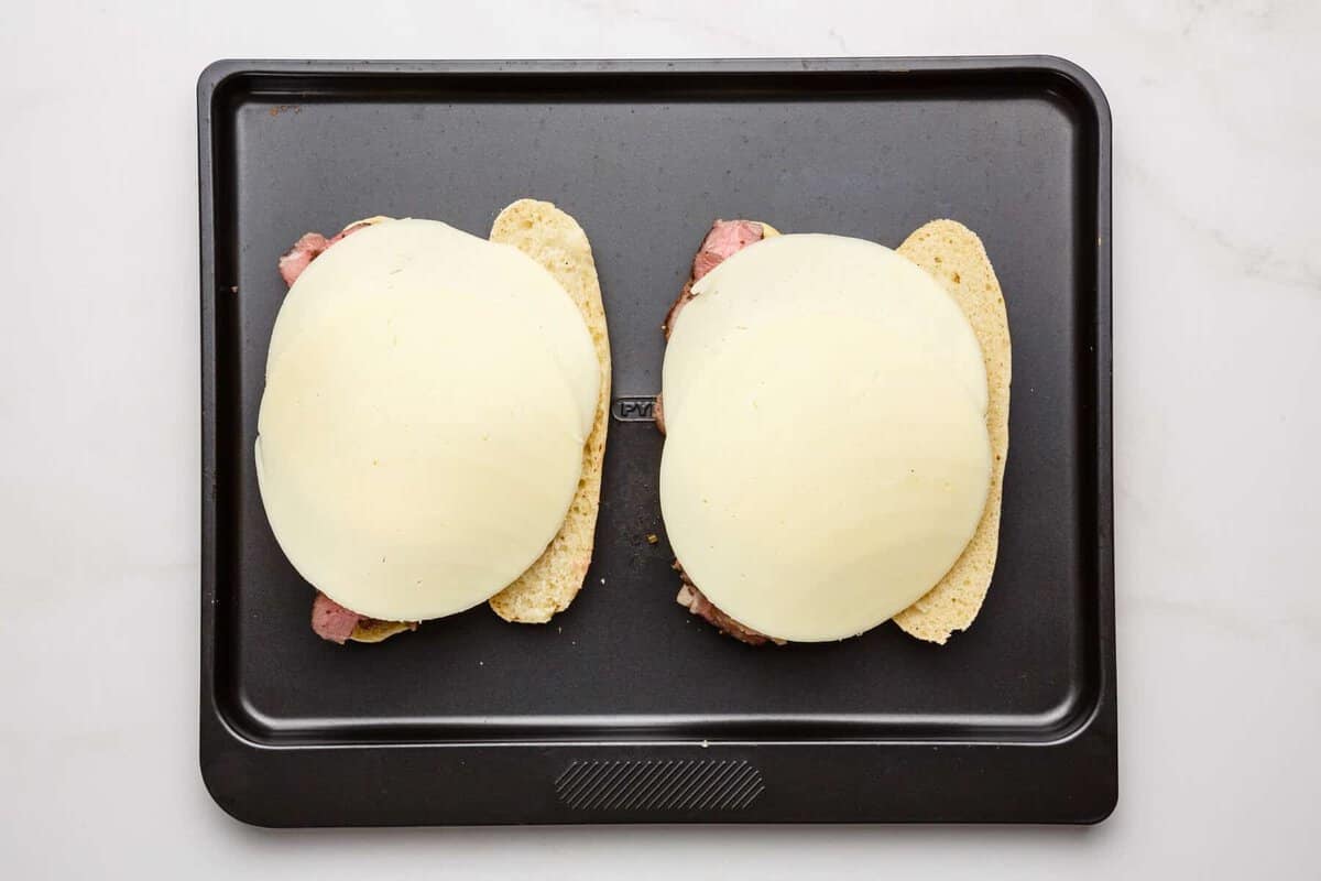 Cheese layered over French dip sandwiches.