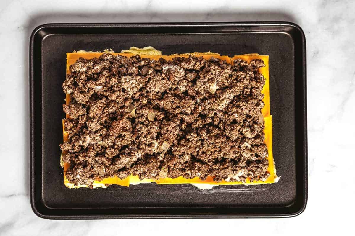 American cheese slices and ground beef on slider rolls.