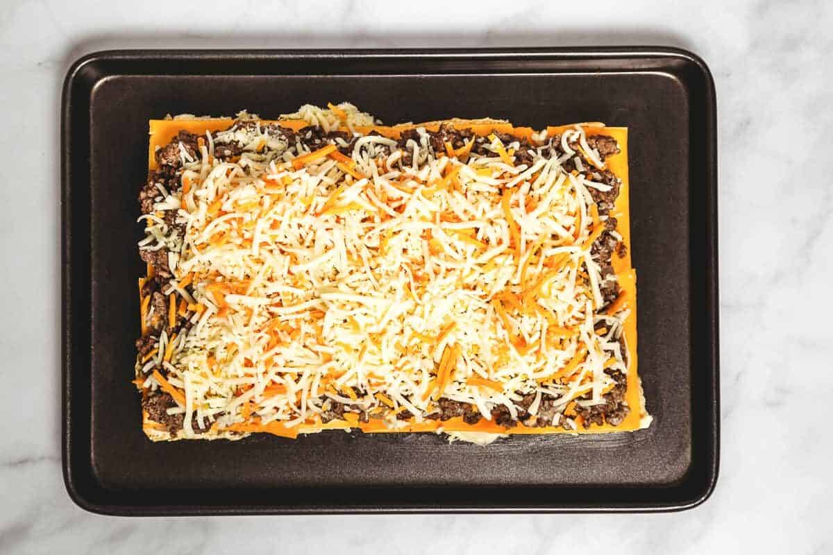 Shredded cheese added to bottoms of slider rolls.