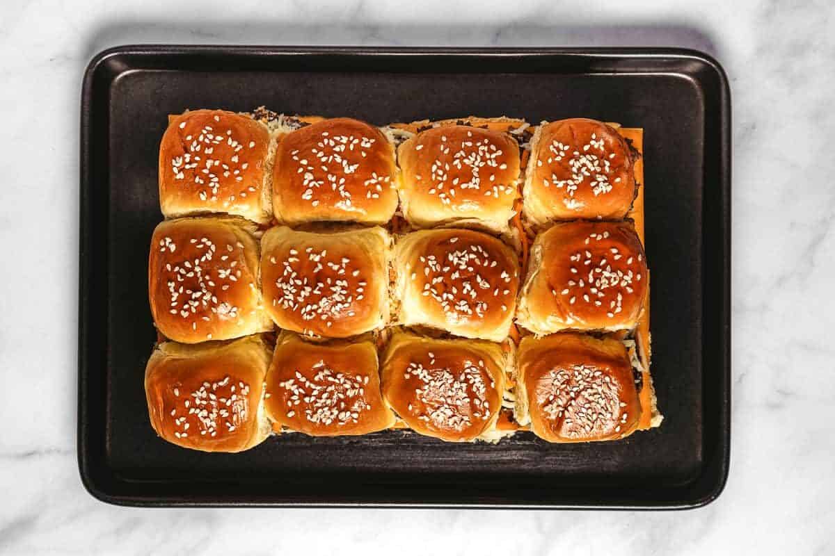 Baked cheeseburger sliders on sheet pan.