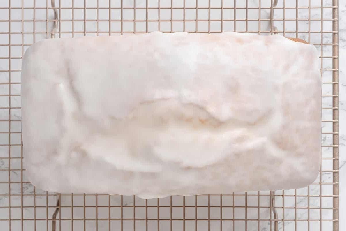 Lemon pound cake with lemon glaze on wire cooling rack.