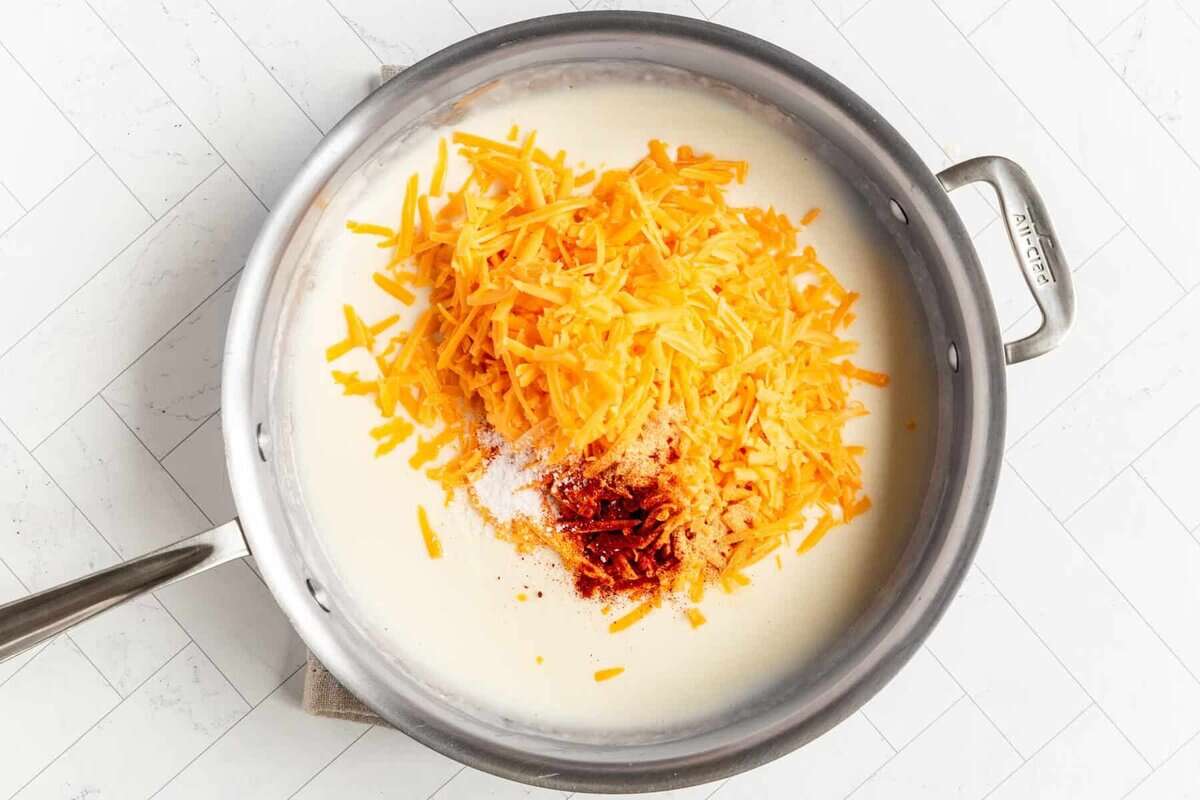 Shredded cheese and seasonings added to roux for pretzel dip.