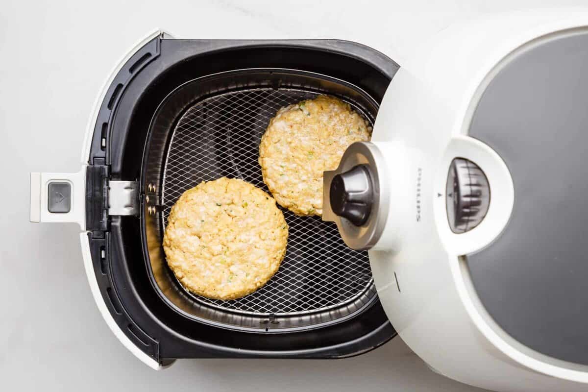 Crab cakes added to air fryer basket.