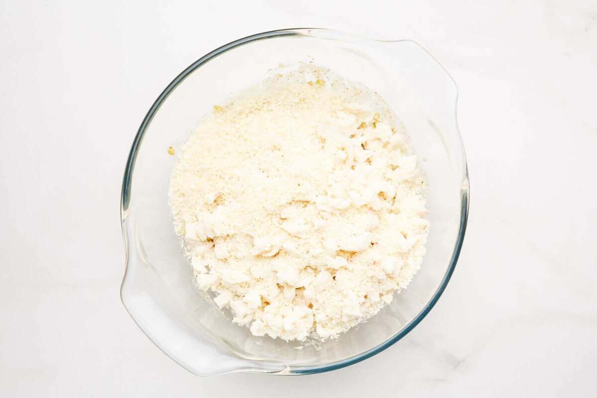 Crab and breadcrumbs added to bowl for air fryer crab cakes.