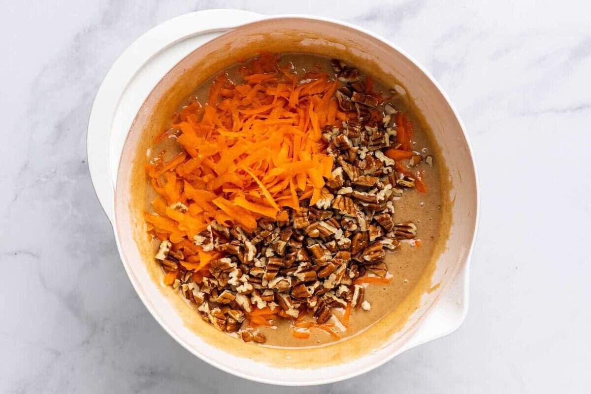 Carrots and pecans added to bowl of cake batter