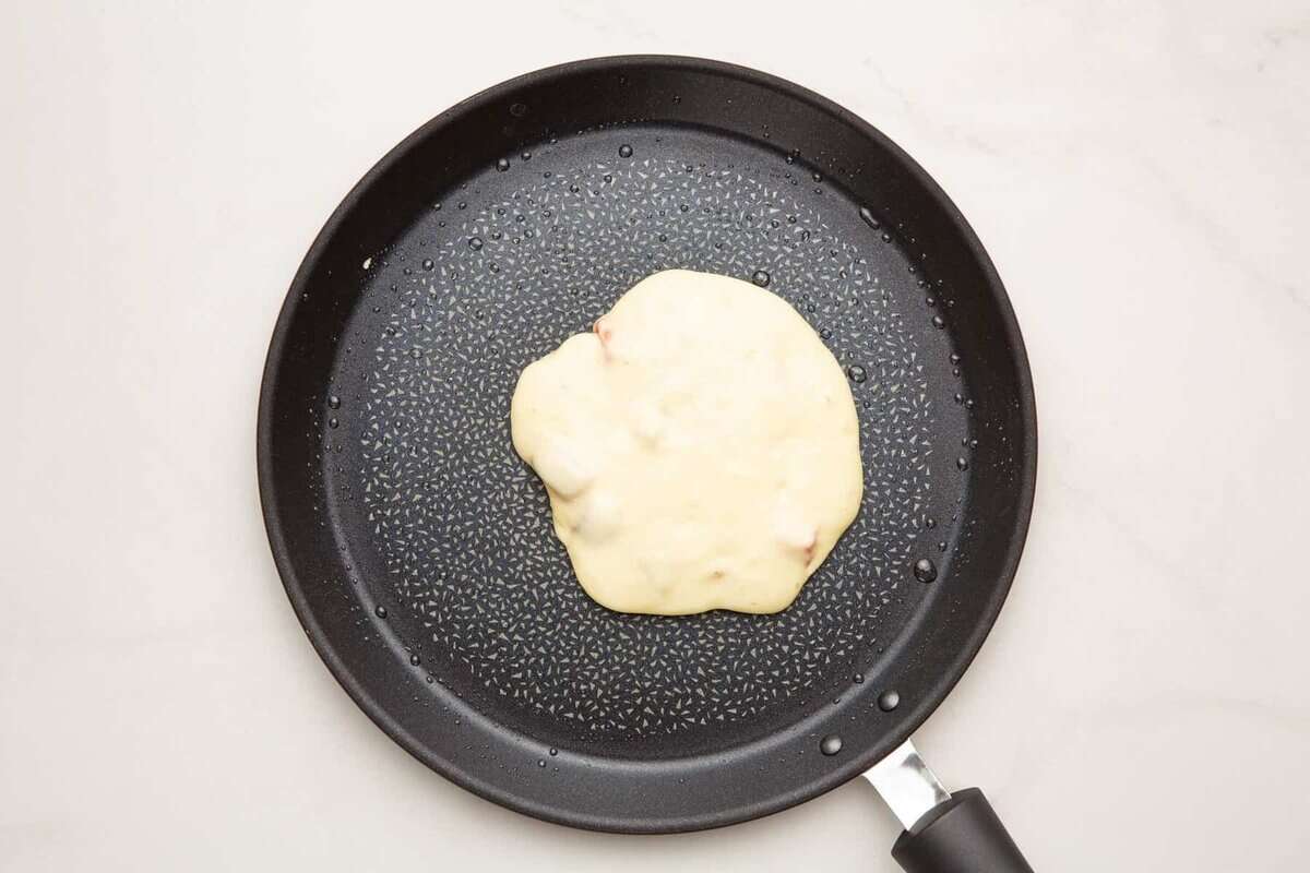 Strawberry pancake batter in skillet.