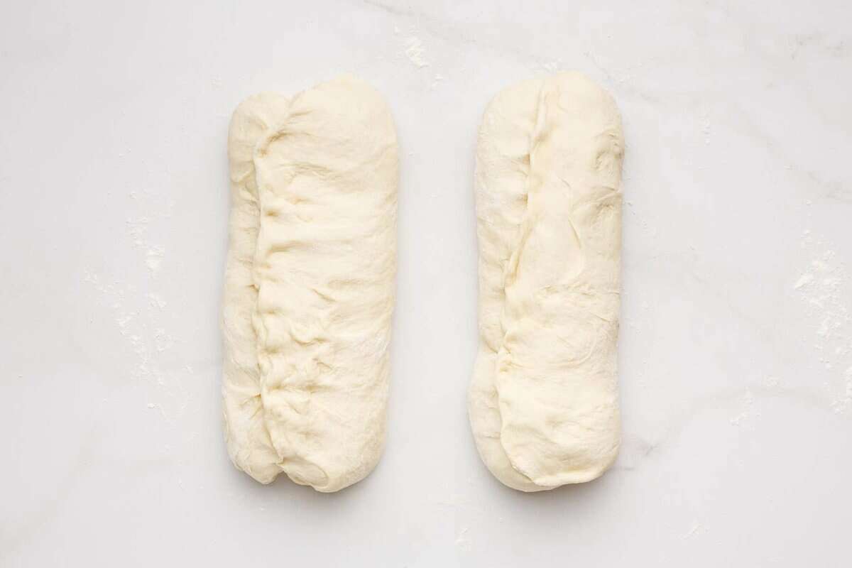 Two loaves of white sandwich bread dough.
