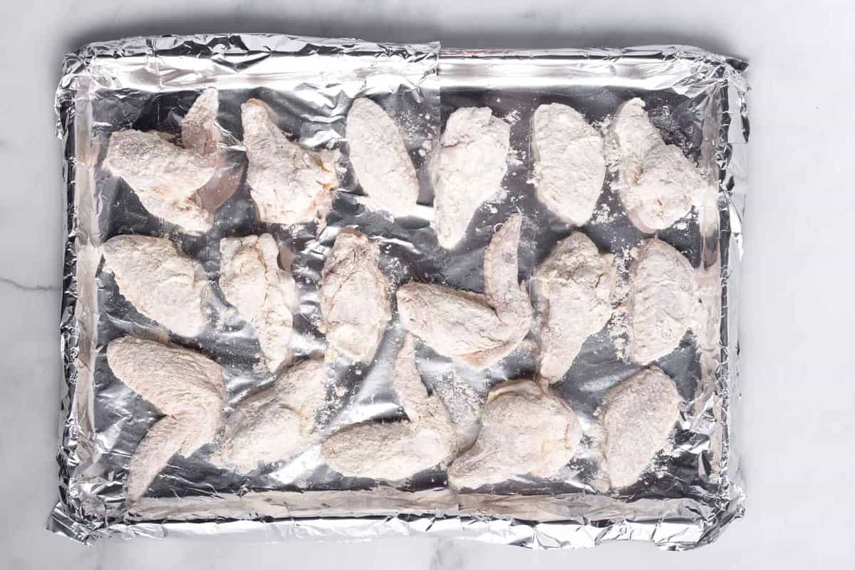 Chicken wings on foil lined baking sheet.