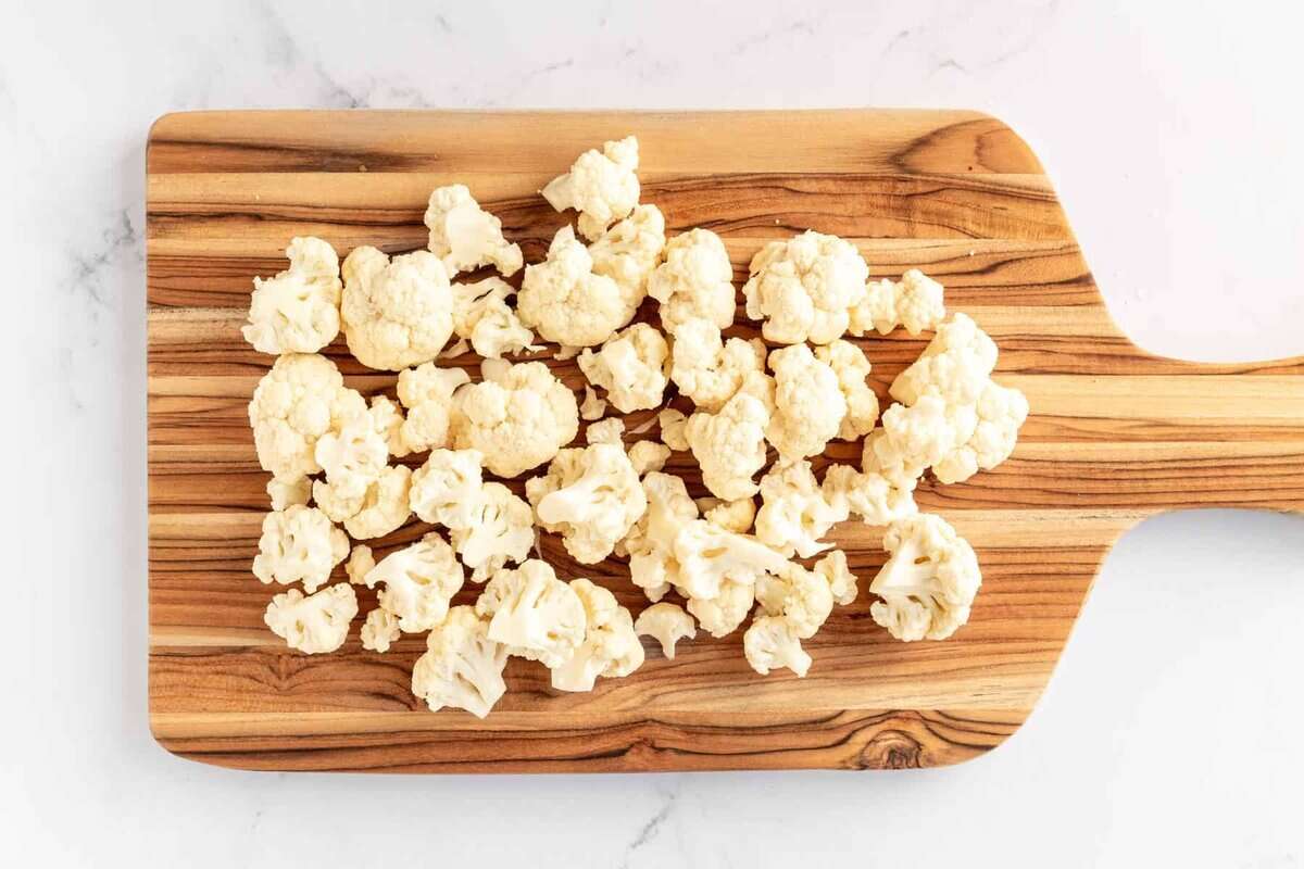 Cauliflower florets on cutting board.