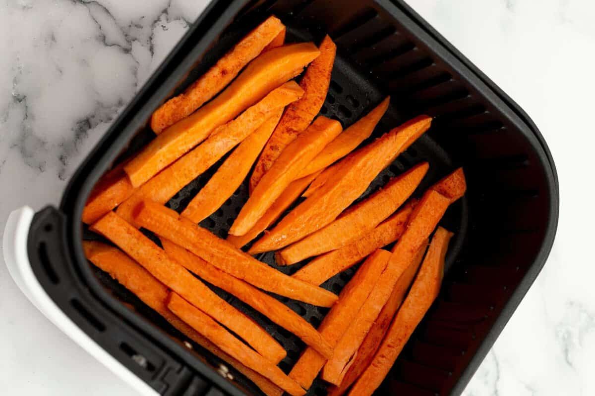 Sweet potato fries added to air fryer basket.