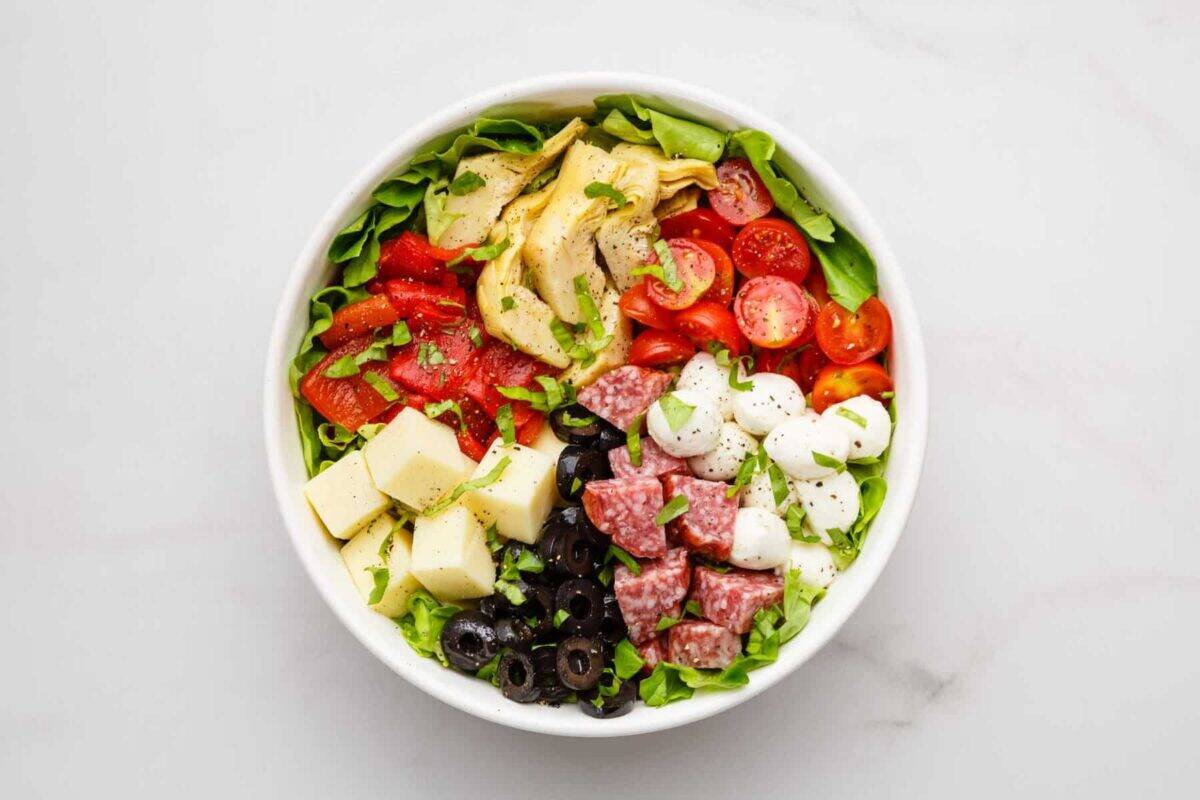 Ingredients for chopped Italian salad in bowl.