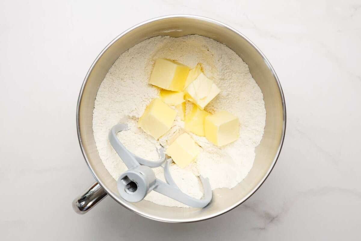 Butter added to mixing bowl with dry ingredients.