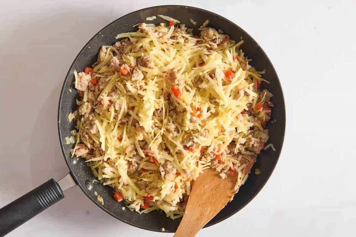 Hashbrowns and veggies in skillet.