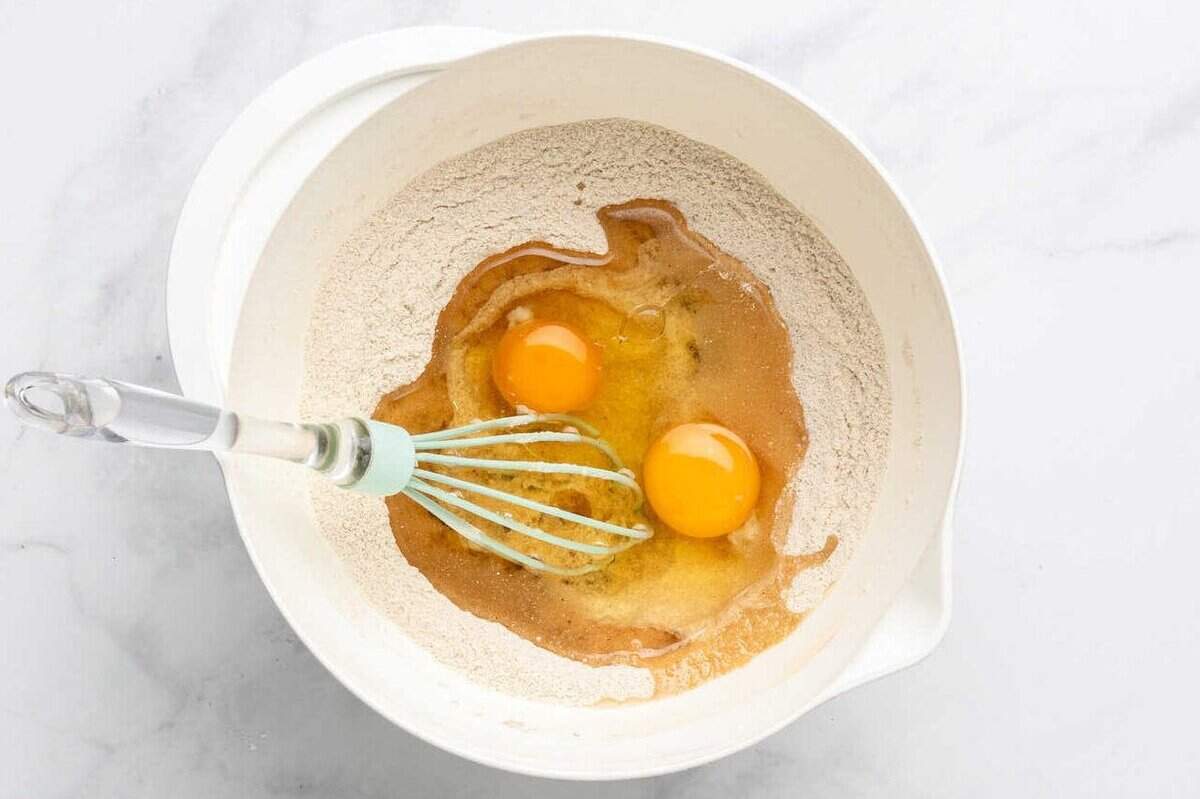 Whisking eggs and oil into dry ingredients.