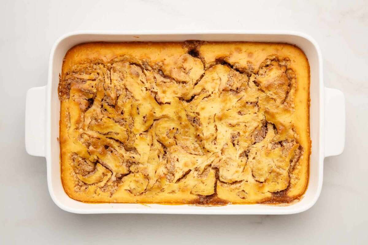 Baked cinnamon roll cake in pan without frosting.