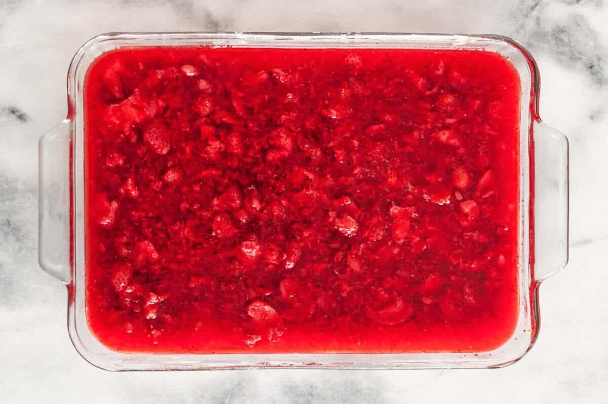 Strawberry jello pretzel salad in casserole dish.