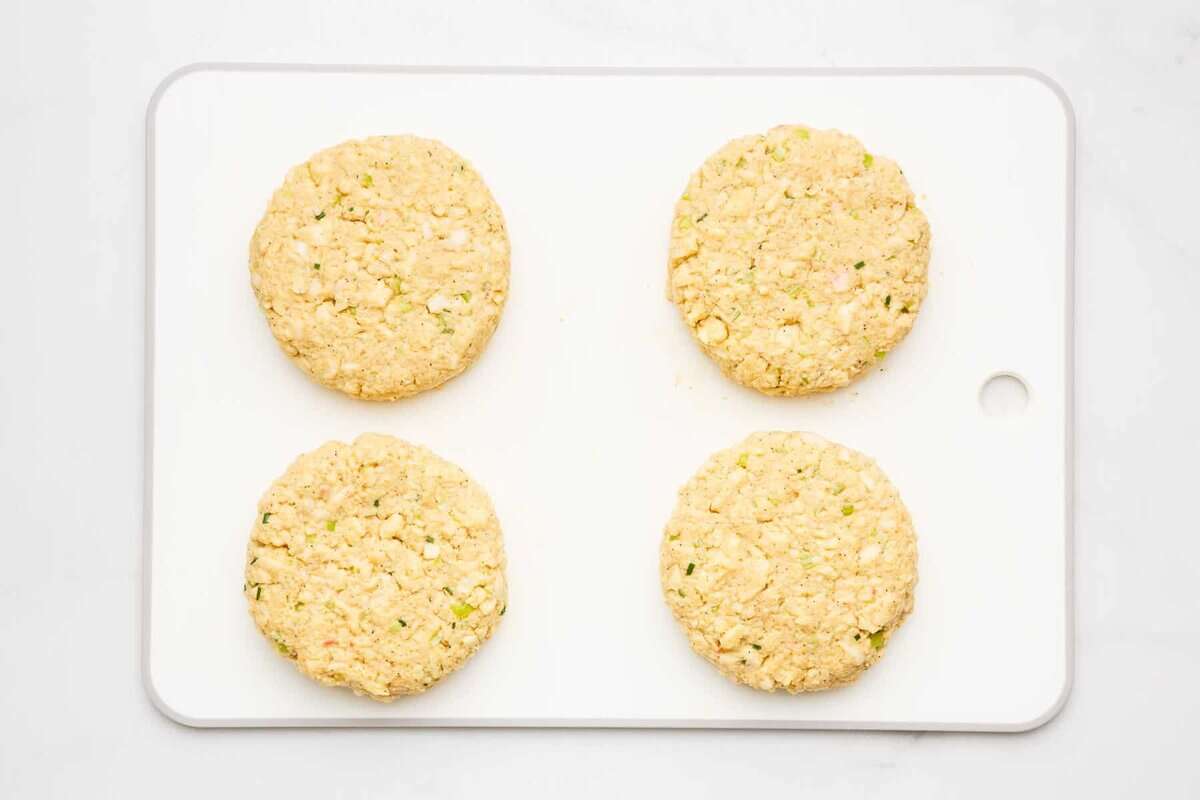 Crab cakes on cutting board before cooking.