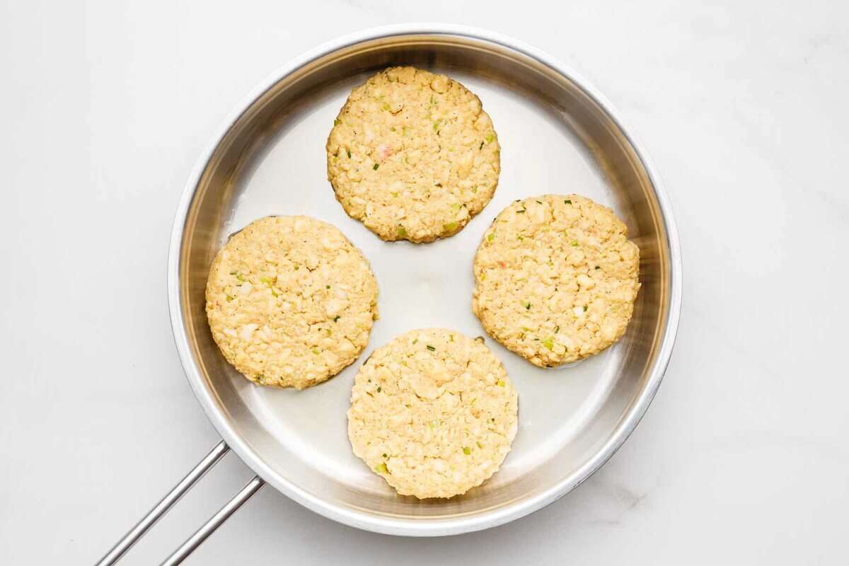 Crab cakes cooking in skillet.