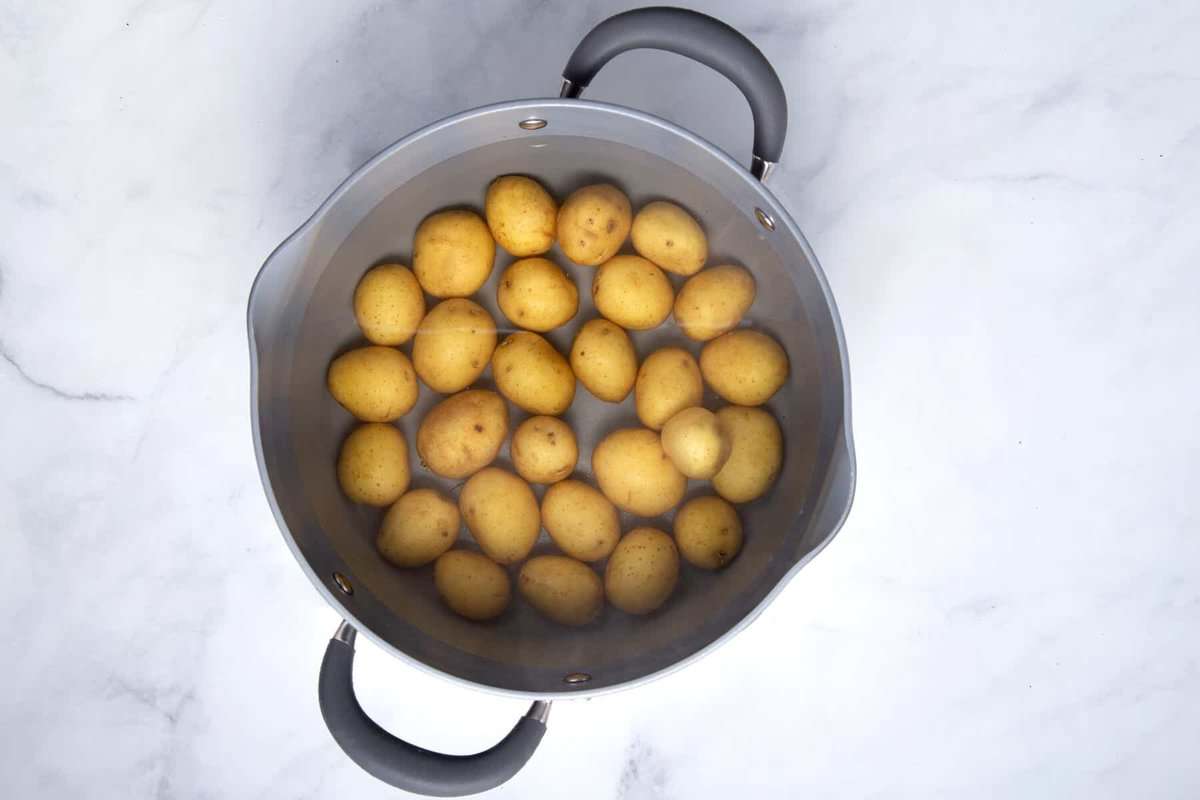Baby potatoes in pot of water.