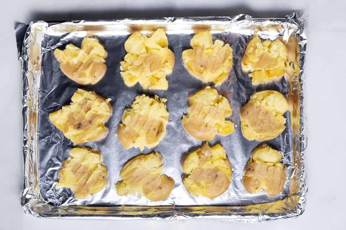 Smashed potatoes on baking sheet before baking.