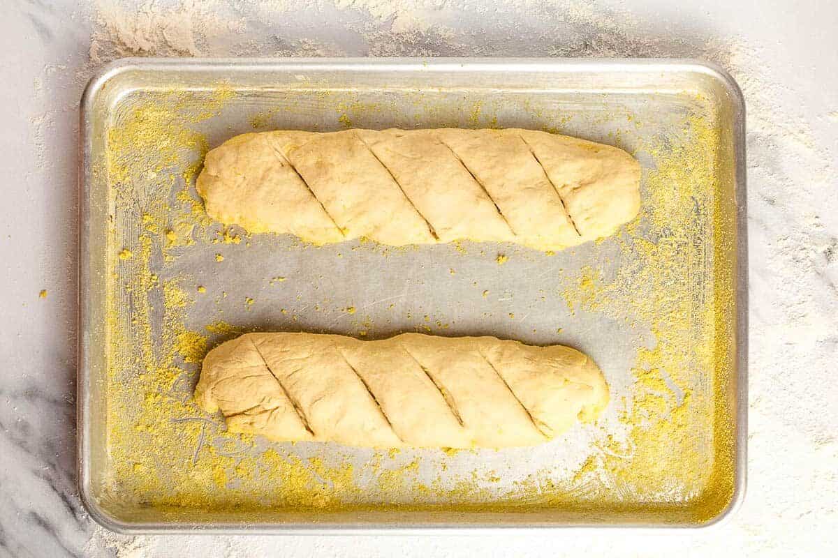 Two unbaked French bread loaves.