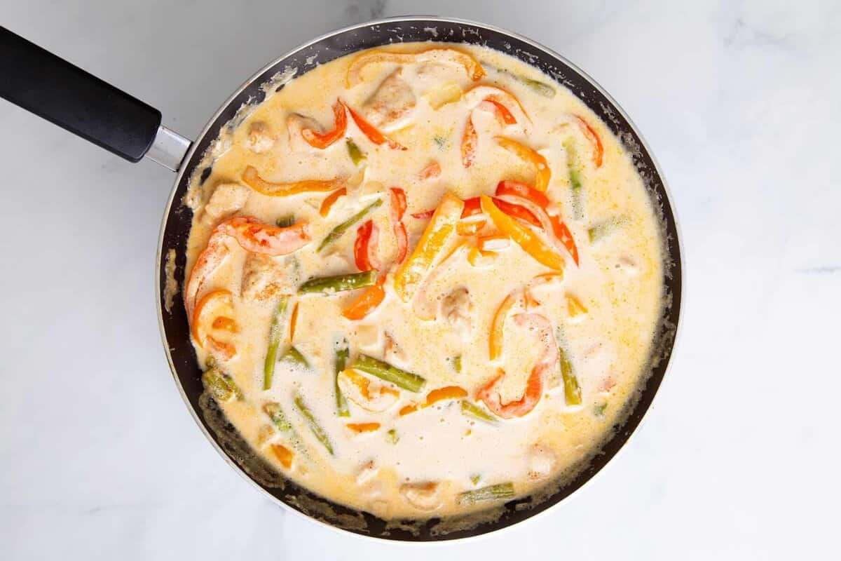 Cream sauce and vegetables in skillet.