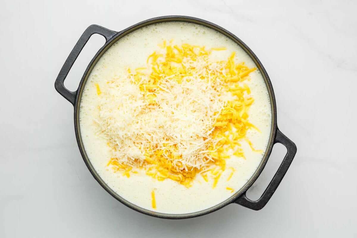 Parmesan and cheddar added to pot of potato soup.