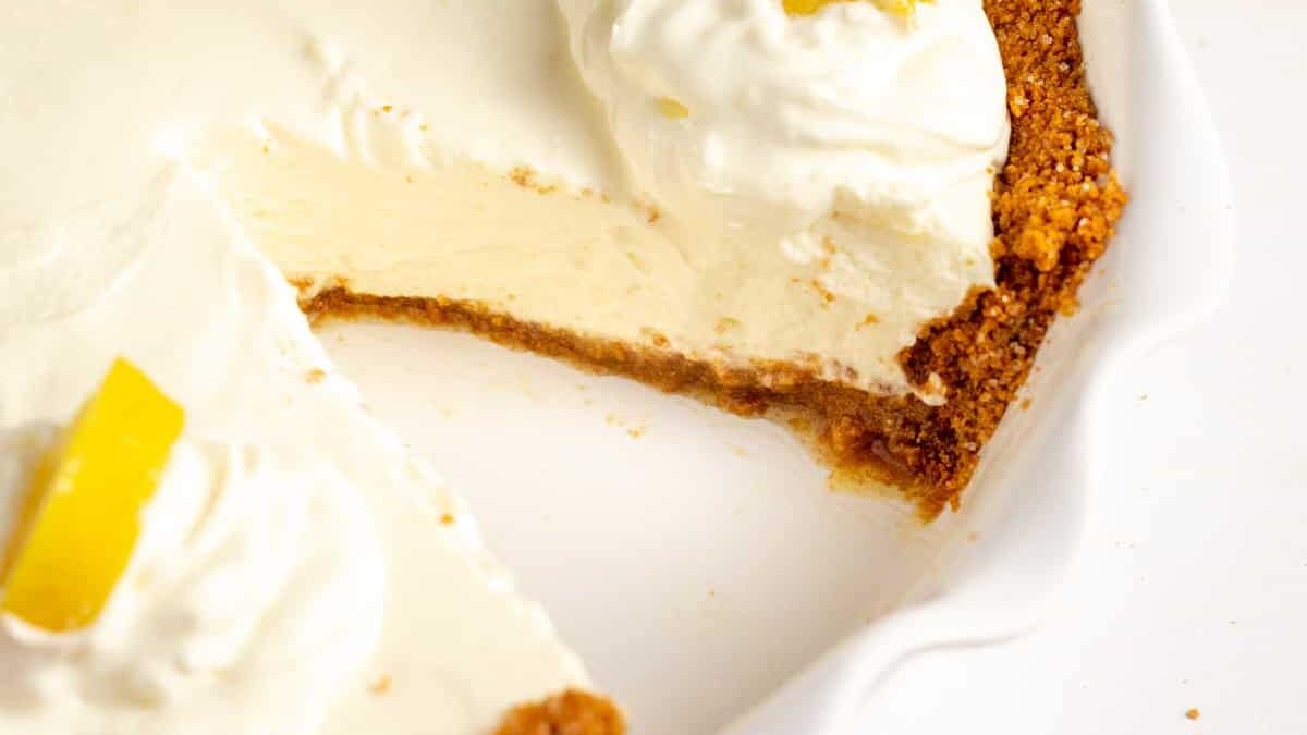 lemon cream pie with graham cracker crust served in a pie dish.