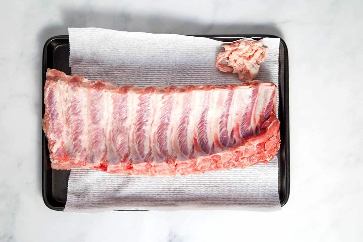Uncooked ribs on sheet pan.