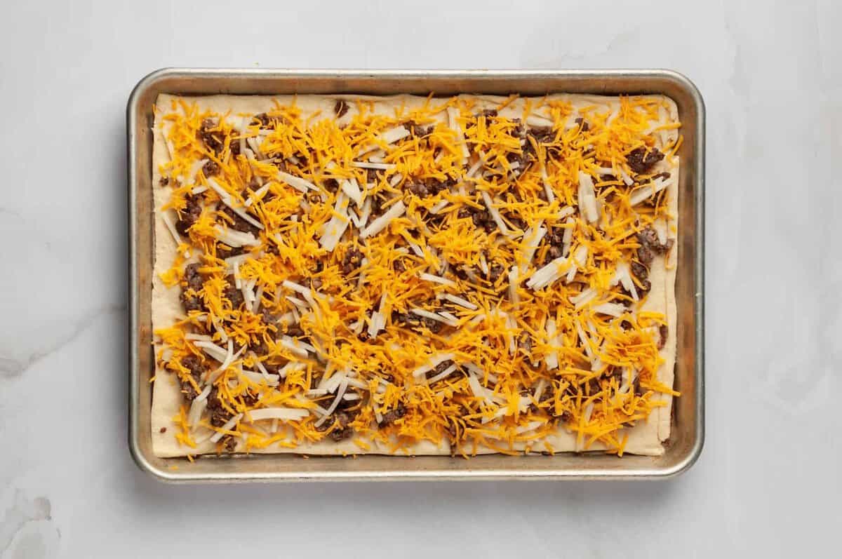 Assembled breakfast pizza on crescent roll crust.