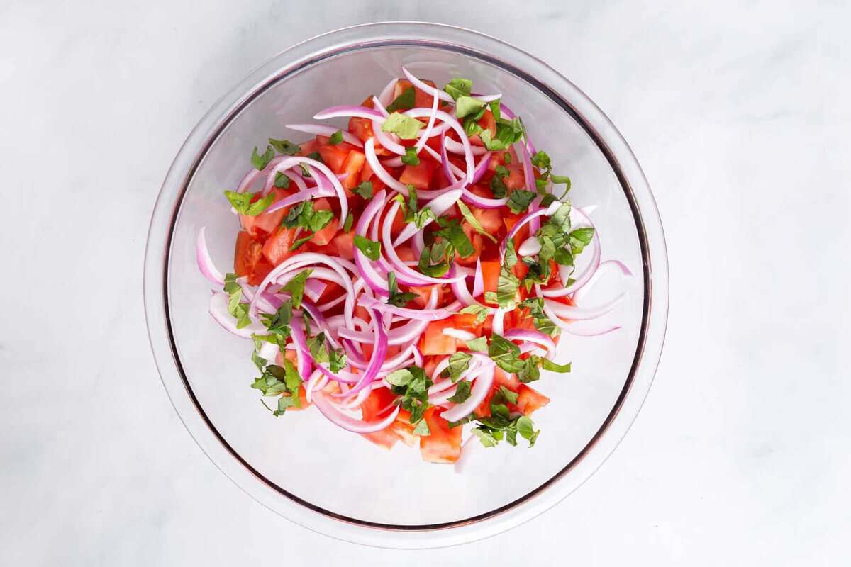 Ingredients for tomato salad in bowl.