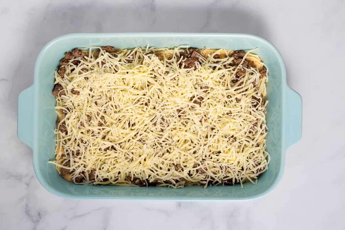 Sausage and cheese added to casserole dish.