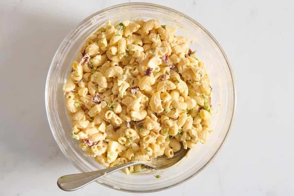 Deviled egg pasta salad in bowl with spoon.