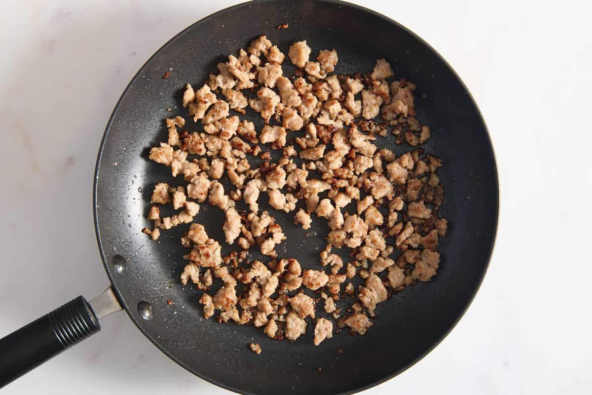Crumbled breakfast sausage in skillet.