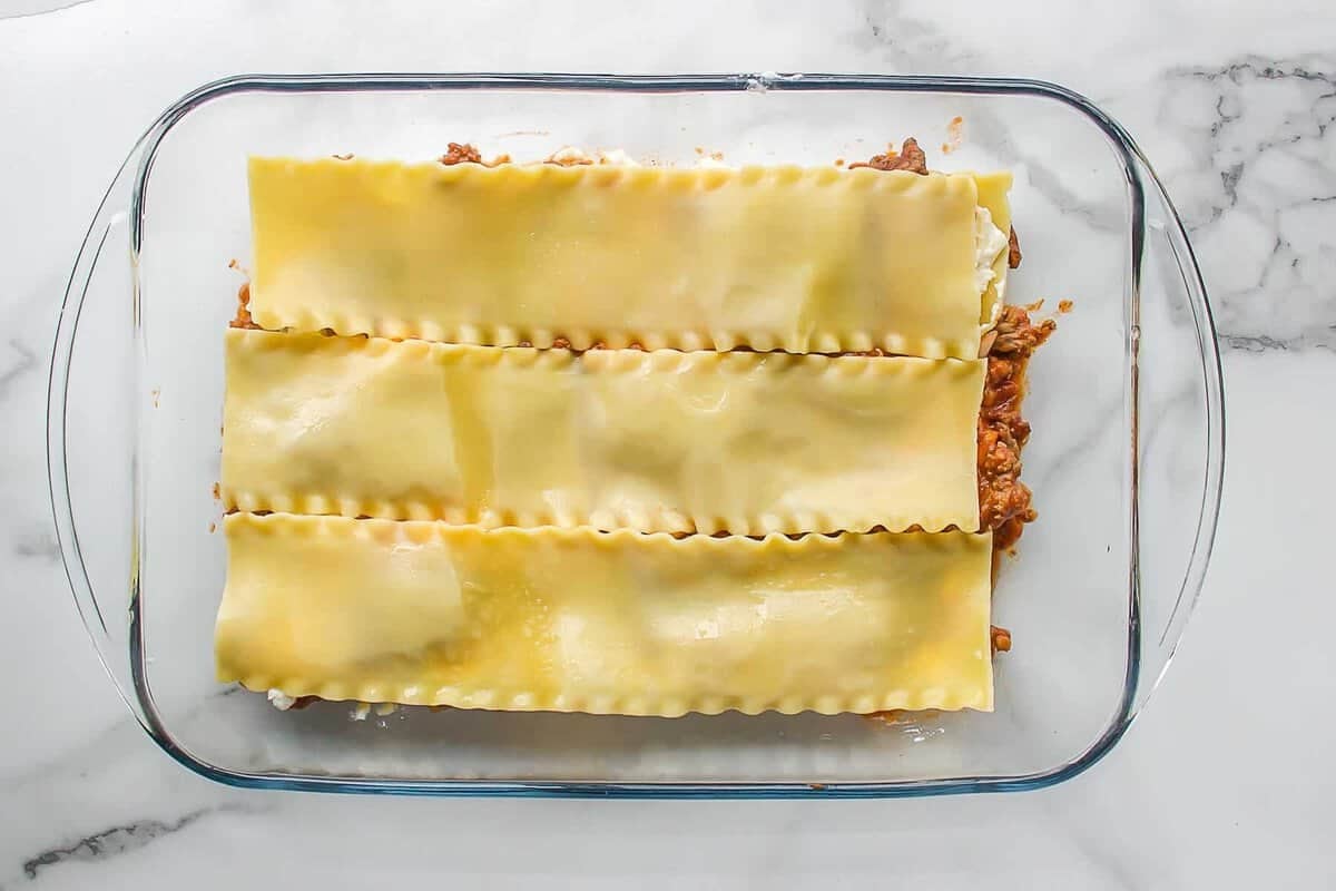 Noodles layered with sauce for lasagna.