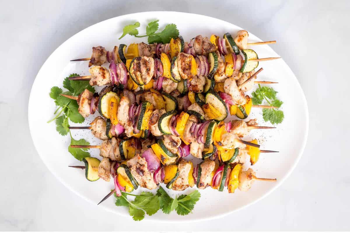Grilled chicken kabobs on platter.