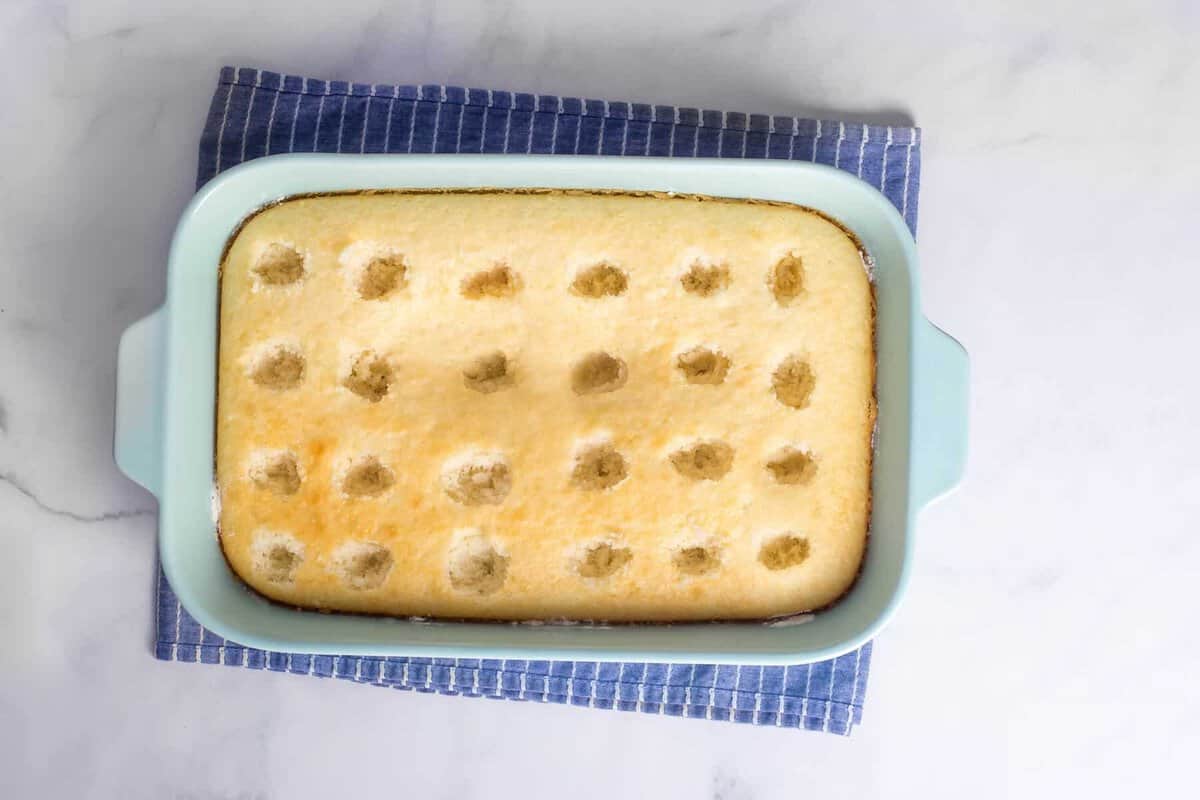 White cake with holes poked throughout.