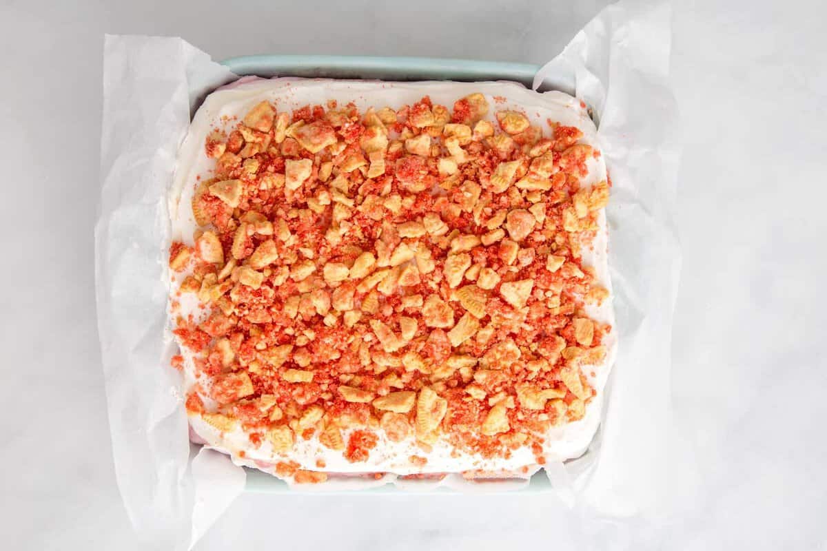 Strawberry crunch ice cream cake in pan.