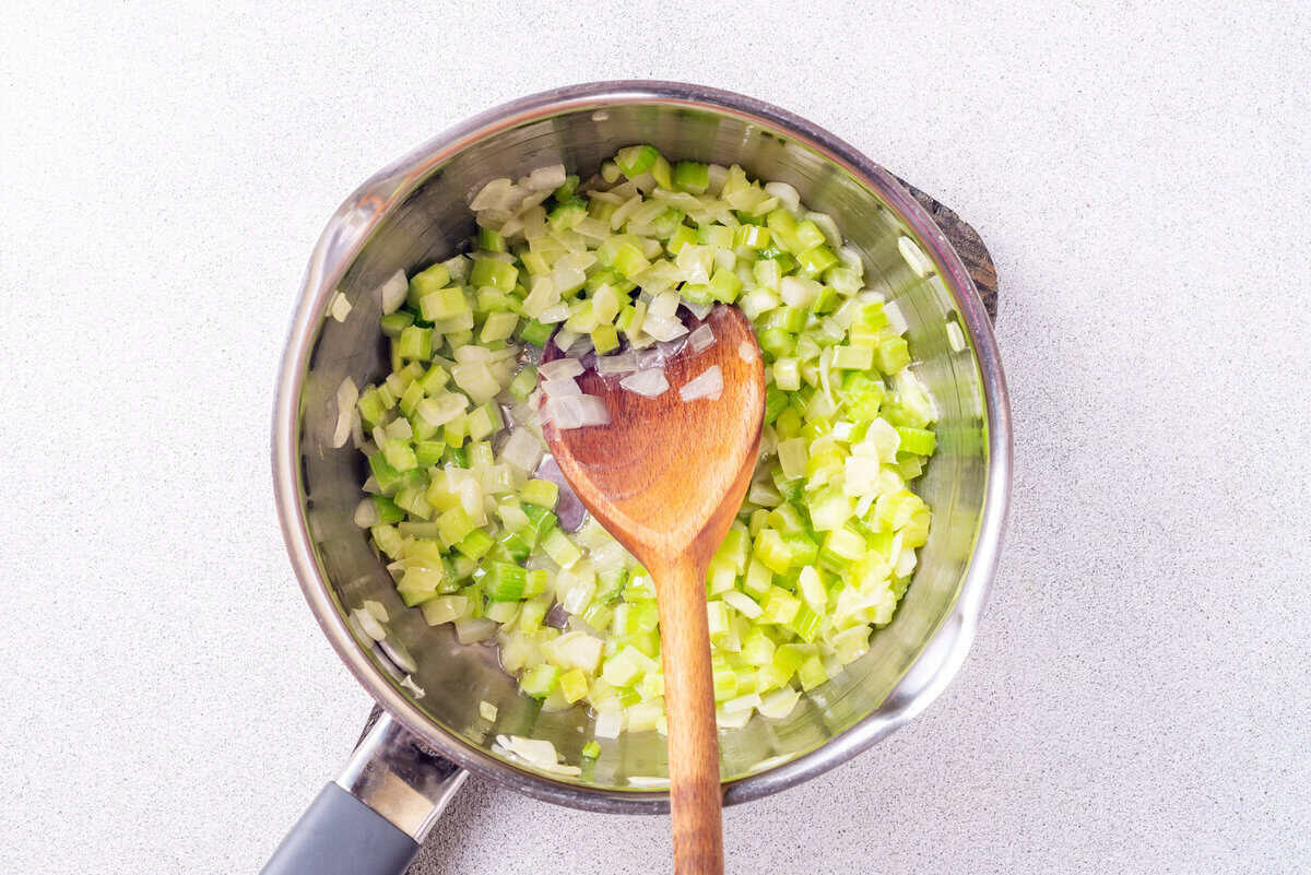 Celery and onions cooking in saucepan.