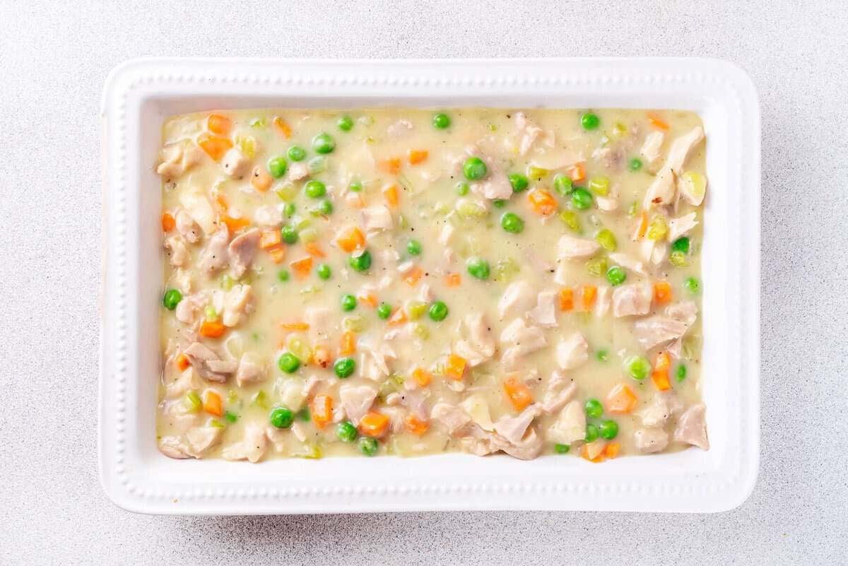 Creamy chicken and vegetable filling in casserole dish.